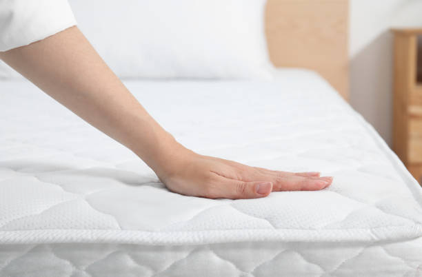 Рука касается поверхности охлаждающего матраса, иллюстрируя, как он регулирует температуру для лучшего сна.